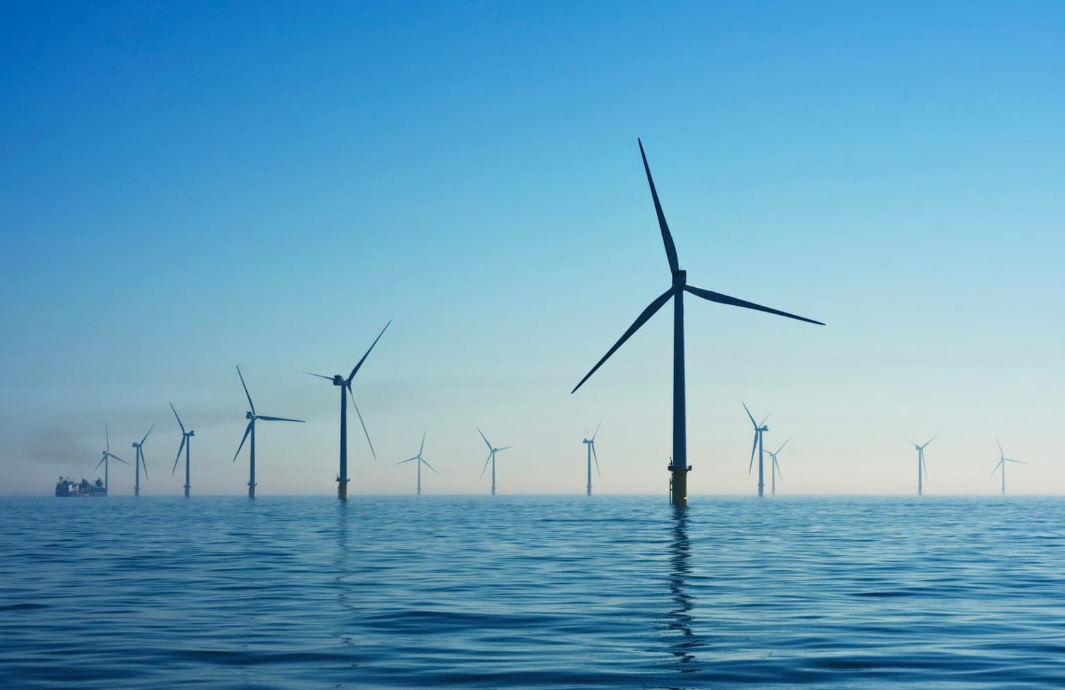Offshore wind turbines standing in calm blue water